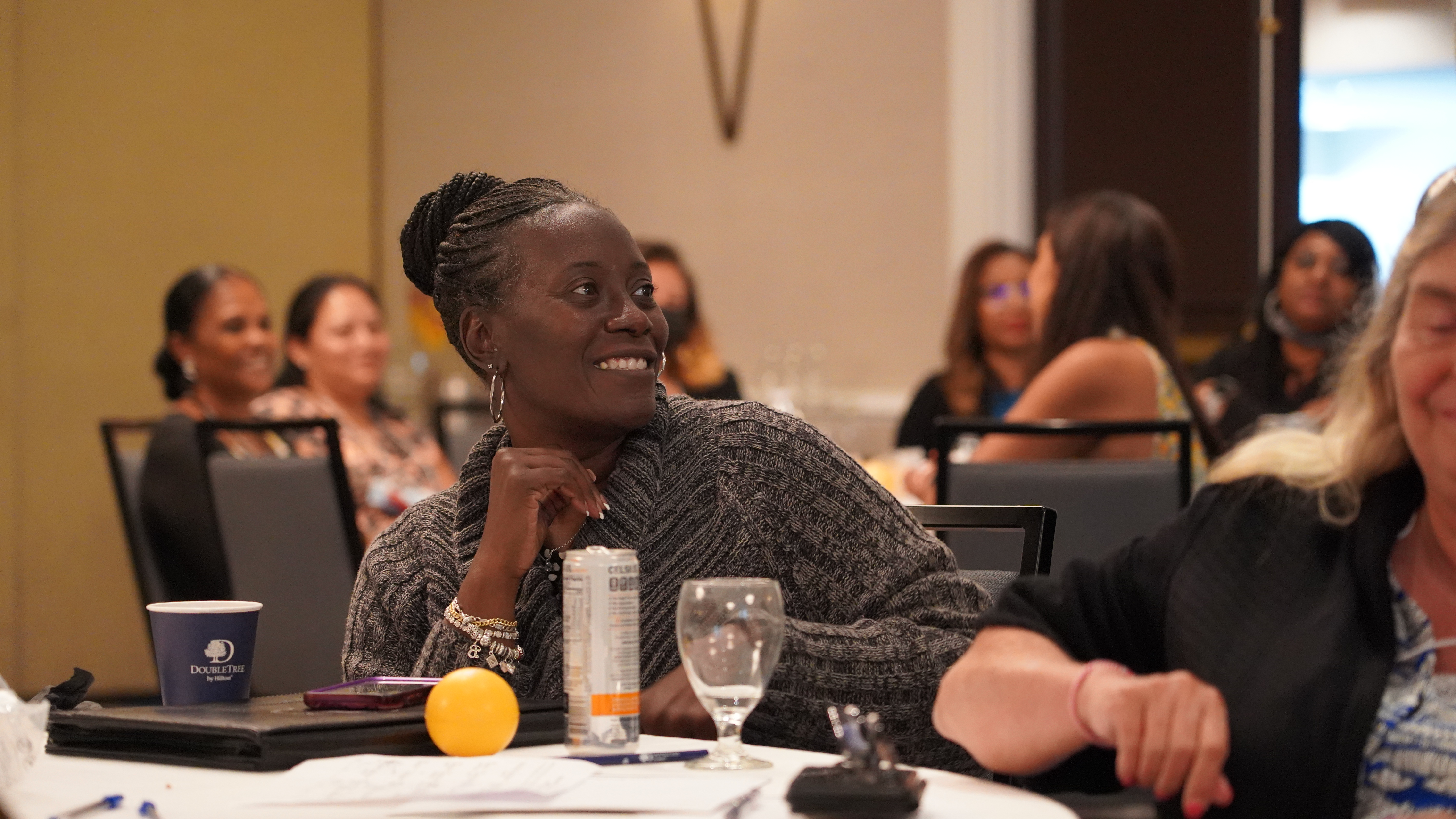 Seminar attendee at her table smiling.